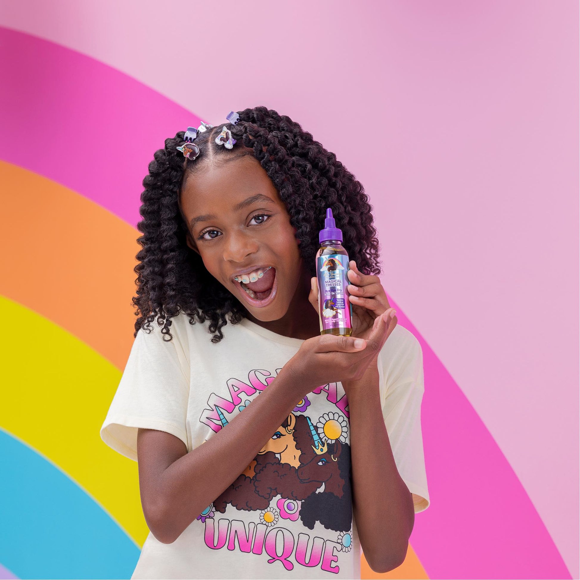 Afro Unicorn model holding a Bye Bye Dry Scalp Serum product.