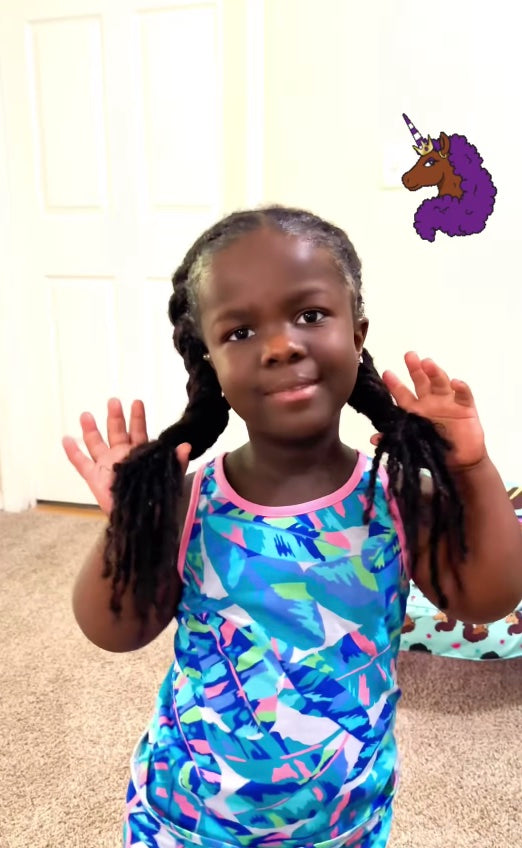 A child showing off her hair while smiling.