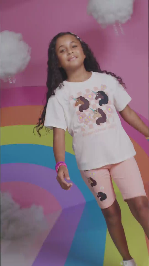 A video of a smiling model showing off Afro Unicorn products with no sound.